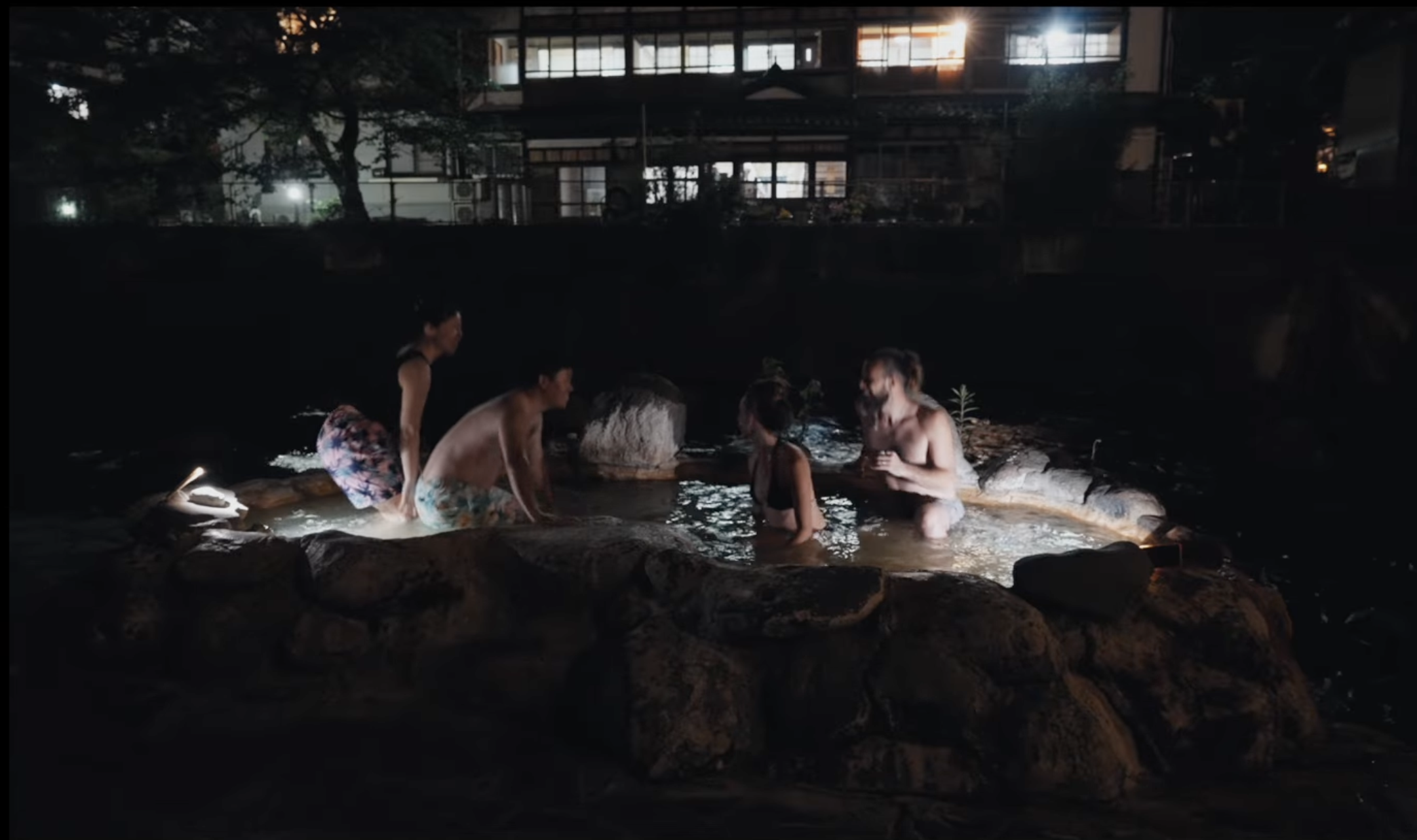 夜のガニ湯で露天風呂を楽しむ旅人たち